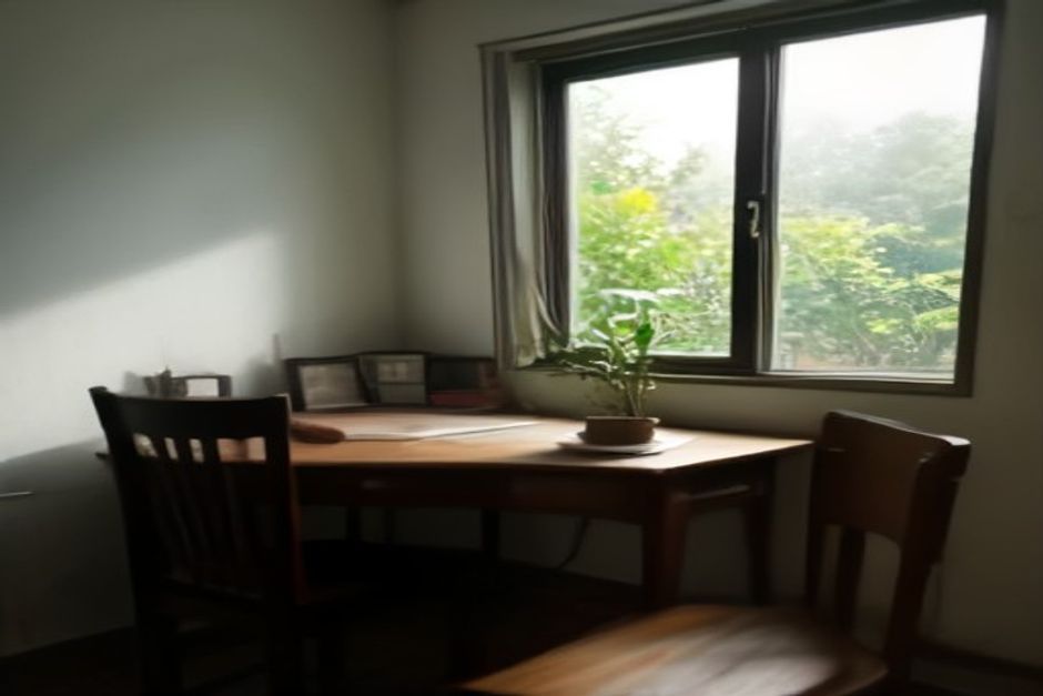 Área de estudos em quarto brasileiro, cadeira vazia, mesa organizada com caderno fechado, planta pequena e janela aberta com luz suave.
