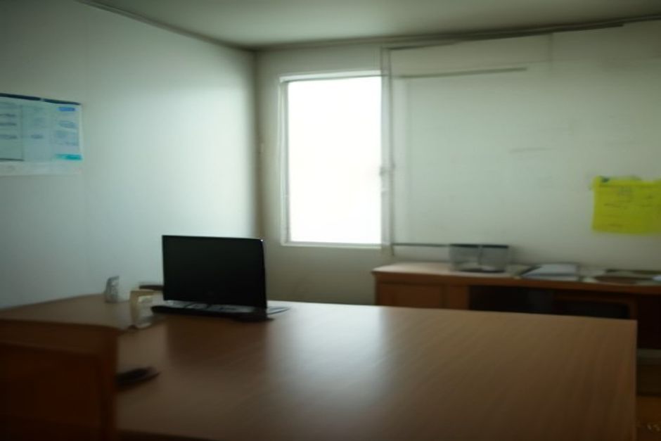 Home office brasileiro com notebook, quadro branco manchado de marcador apagado e post-its coloridos espalhados, tudo com luz natural suave.